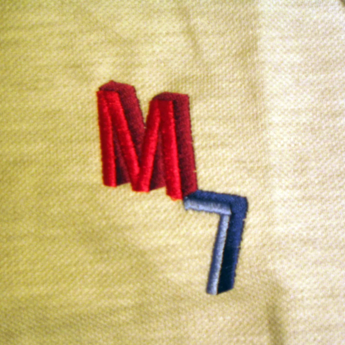 Embroidered M7 mark in red and blue thread