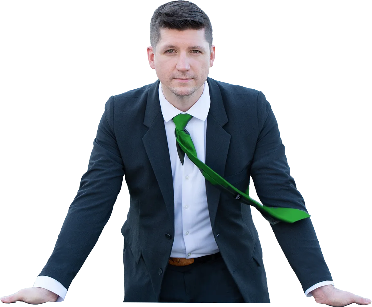 Scott Cress in a dark suit leaning on a table, his green tie blown sideways