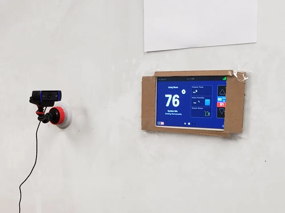 A thermostat prototype on a wall with a camera pointed at it